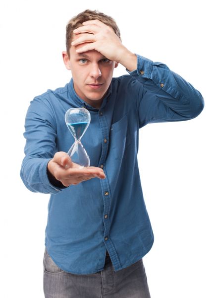 Man holding hourglas with hand at his head